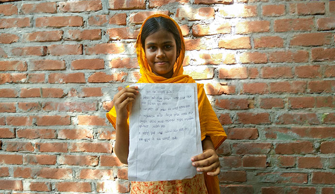 Young girl holding a handwritten educational poster raising awareness against human trafficking