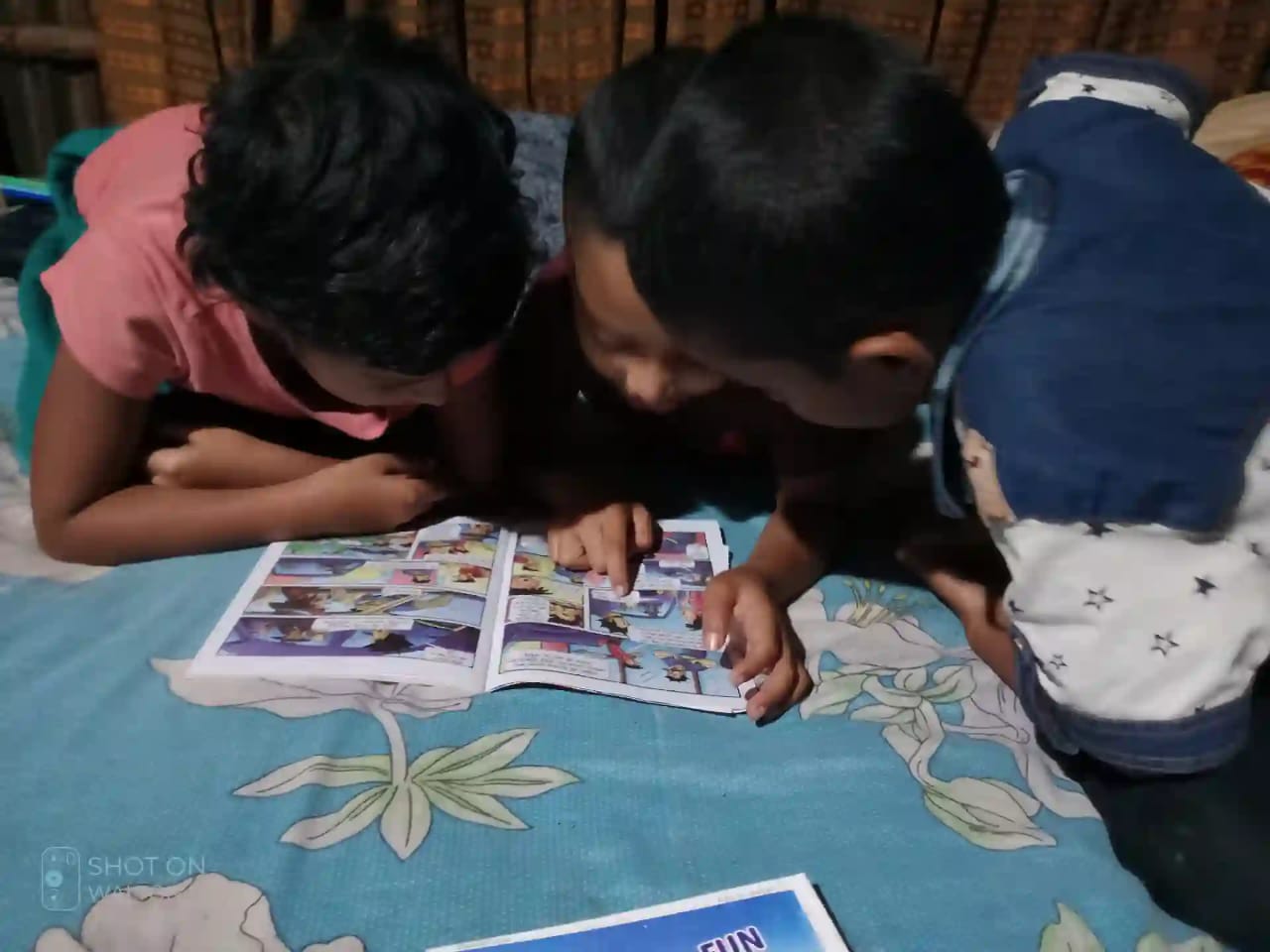 kids in Mirpur reading a book from our library