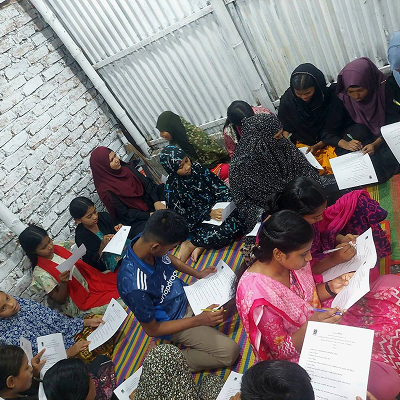 Kids filling out survey forms regarding the session of Menstrual health awareness