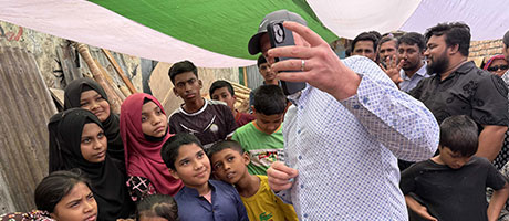Sam showing his kids's picture to the sponsored kids