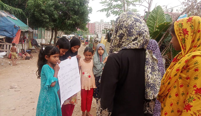 Children holding an informative sign on preventing Aedes mosquito breeding in the community
