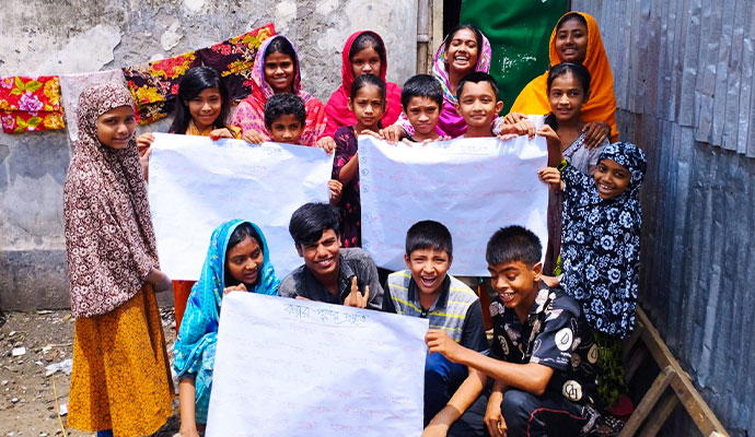 Group of children holding handwritten educational posters about flood safety and preparedness