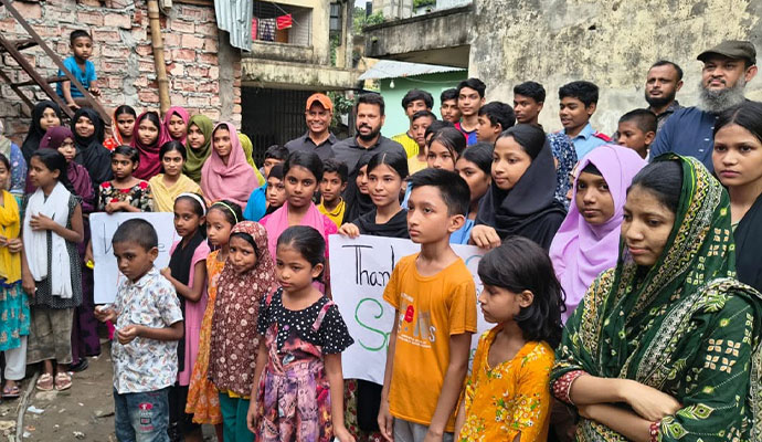 Children and community leaders holding thank you signs for Shapla Foundation project sponsors