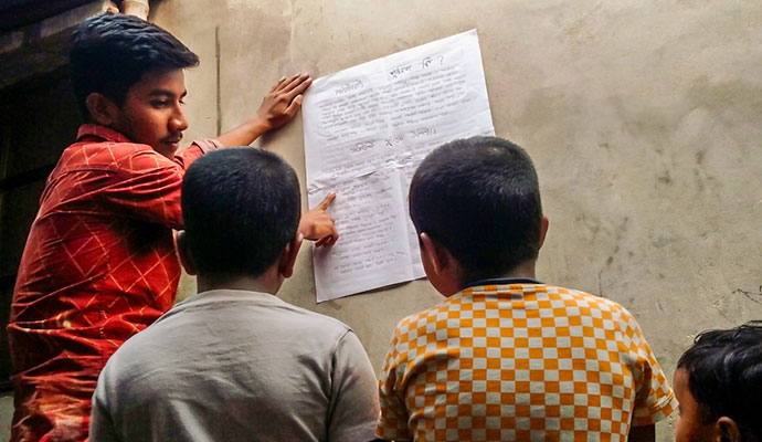 Boy explaining a community policing and safety information chart to young children