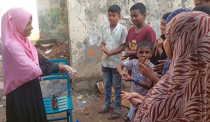Instructor demonstrating proper handwashing and sanitizing techniques to children