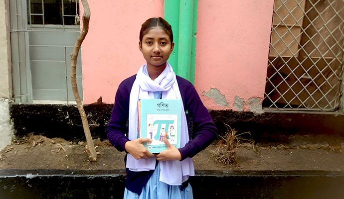 Smiling student in uniform holding her book