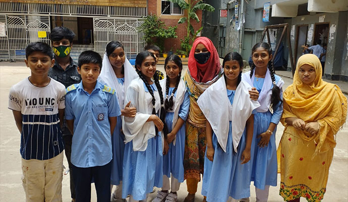 Group of school children and teachers standing together in a school courtyard