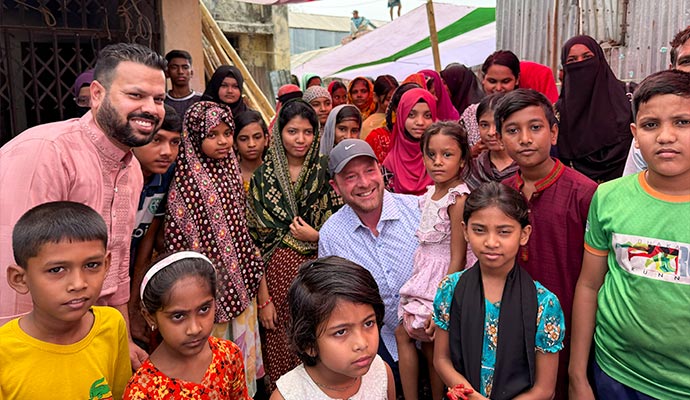 Sponsor and foundation representative smiling with children and families in a community
