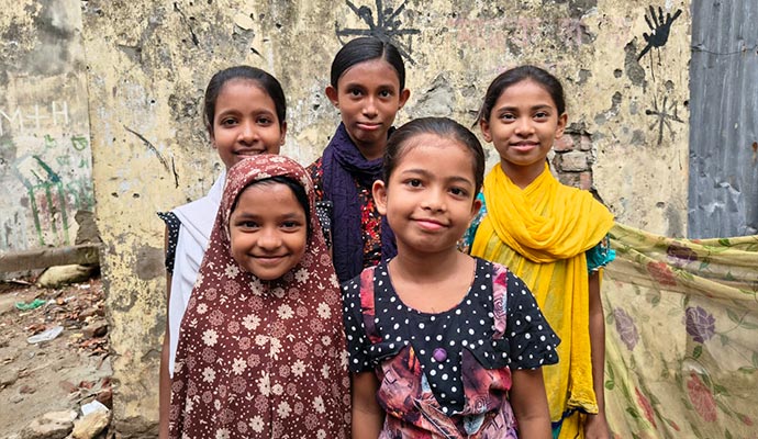 Group of young sponsored Bangladeshi girls smiling together outdoors